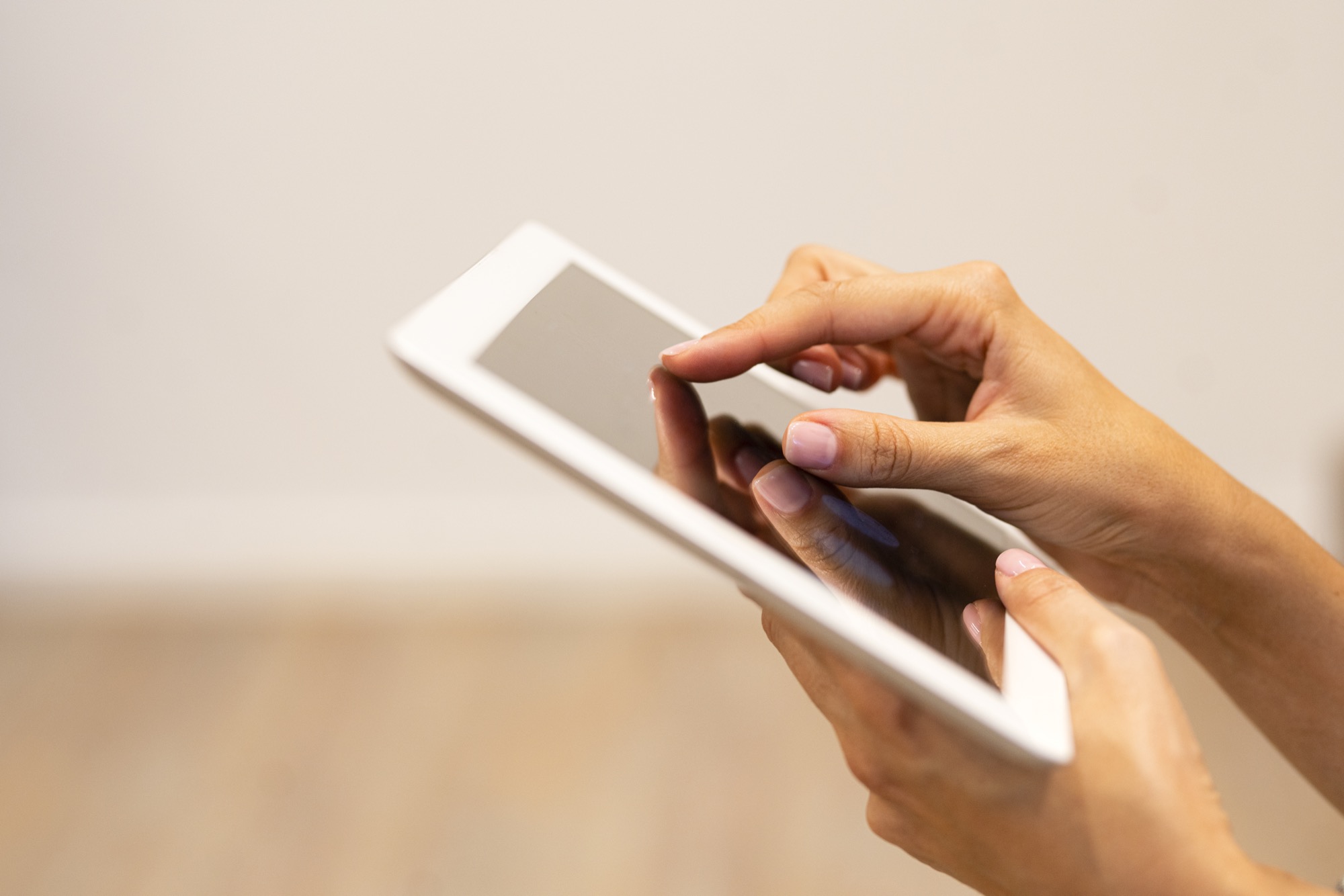 Nahaufnahme von Händen, die ein Tablet bedienen – digitale Datenerfassung in der Praxis.